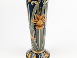 un vase bleu orné de fleurs jaunes sur fond blanc