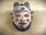 a mask with a bow on it on the wall