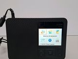 an image of a black radio with a charger plugged into it
