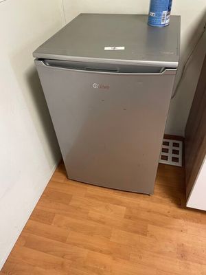 a small refrigerator in the corner of a room