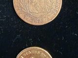 two gold coins sitting next to each other on a black surface