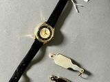 a watch that is laying on a table next to other items
