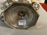 a close up of a silver candle holder on a table