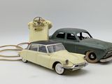 two toy cars sitting next to each other on a white surface