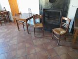 tables and chairs in a room with a fire place in the background