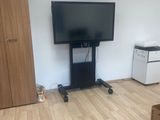 un téléviseur à écran plat posé sur un support dans le coin d'une pièce
