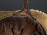 an old helmet with a metal handle on top of a table