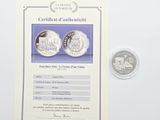 a certificate of authenticity of a coin with a picture of a train on it