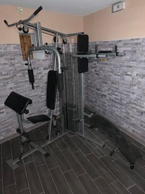 une photo d'une salle de sport à domicile équipée d'un banc et d'appareils de musculation