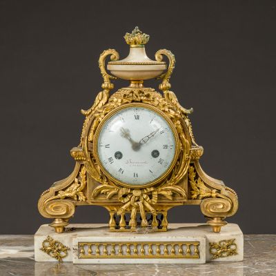 a gold clock sitting on top of a marble table