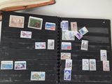 a book with stamps on it sitting on a table next to an open book