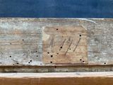 a piece of wood with writing on it sitting on a bench