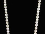 three pearl necklaces and a pearl necklace on a black background