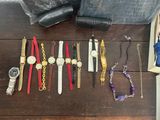 many watches and bracelets laid out on a table
