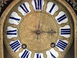 a gold clock with blue and white roman numerals on it