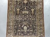 a black and beige rug with a floral design on it