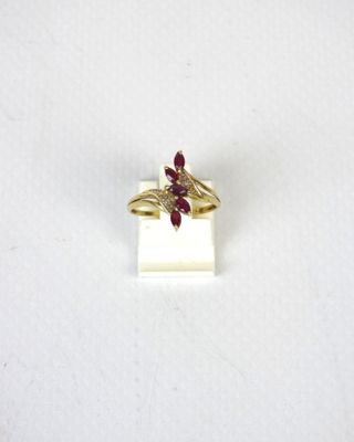 un gros plan d'une bague en or ornée d'une fleur rouge