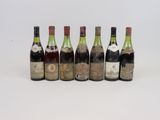 six bouteilles de vin sont alignées sur une surface blanche