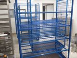 a blue cart in the middle of a kitchen with a lot of shelves