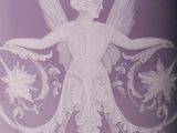purple vase with a white angel on it sitting on a table