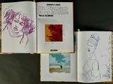 three books on a table with drawings of a woman and a man