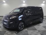 La camionnette noire est garée sur un sol en dalles à damier.