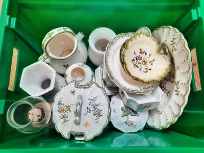 a green container filled with tea cups and saucers