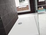 une douche avec une porte vitrée au milieu de la salle de bains