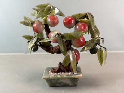 un petit bonsaï portant des fruits rouges