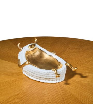 une figurine de grenouille en or posée sur une table en bois