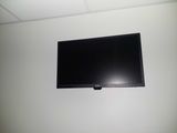 a flat screen tv mounted on the wall above a bed