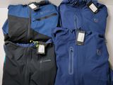 three pairs of blue and black jackets sitting on top of a table