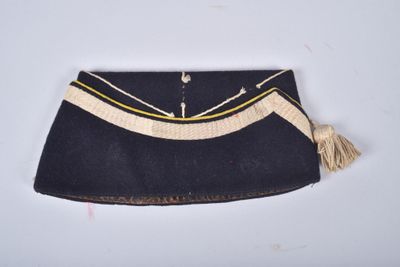 un vieux sac à main avec un pompon qui pend sur le côté