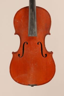 an old violin sitting on top of a white surface
