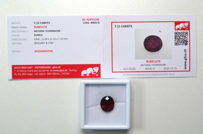 un gros plan sur un diamant rouge dans une boîte posée sur une table