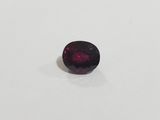 a red garnet stone on a white surface
