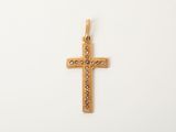 un pendentif en forme de croix en or, orné de petits diamants sur fond blanc
