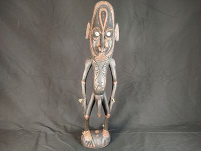 une image représentant une statue en bois d'un homme sur fond noir