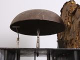 a clock that is sitting on a shelf next to a tree