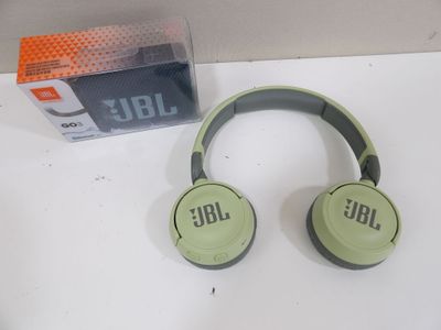 Le casque JBL est posé sur la table, à côté de la boîte.