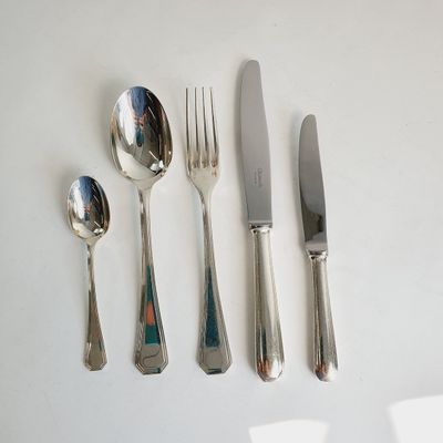 four forks, a spoon, and a knife on a table