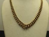 a close up of a gold chain necklace on a mannequin