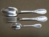 trois cuillères en argent et une fourchette posées sur un fond marron