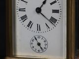 a small clock with roman numerals on the face