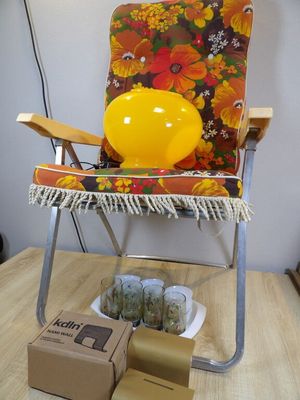 un ballon jaune posé sur une chaise, à côté d'une boîte