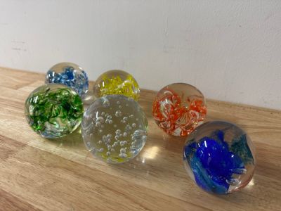 four glass marbles sitting on top of a wooden table