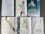 several books with drawings of people and birds in them on top of a table