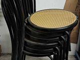 quatre chaises noires avec une assise en osier