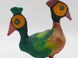 a colorful bird that is standing on a wooden stand