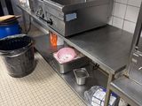 une cuisine avec de nombreux plans de travail en inox